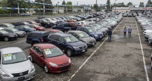 Rangées de voitures d'occasion sur un parking de concessionnaire